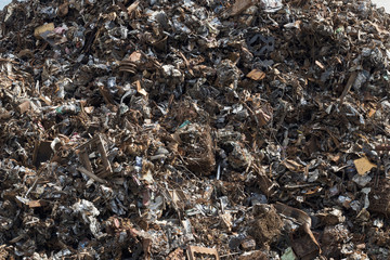 Background image of a mountain of rusty scrap metal.