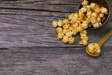 Caramel popcorn in the bowl wooden background.