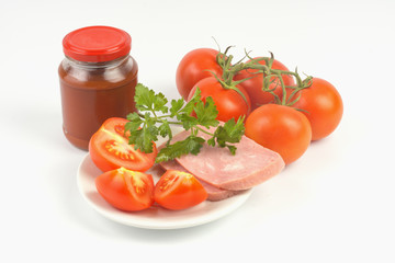 Tomato paste in a jar and tomatoes on an isolated background