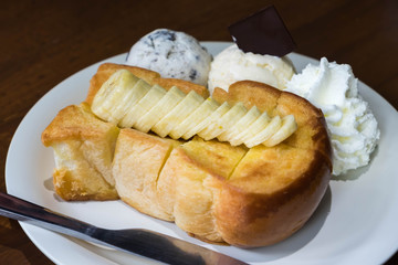 Honey toast bread serve with banana, ice cream and whipped cream