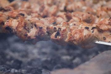 Pieces of shish kebab on a skewer with smoke close