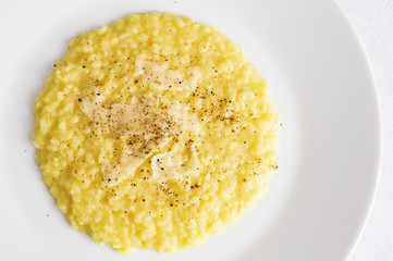 Fototapeta premium rice and onion cooked on broth coloured with saffron and white wine with cheese added