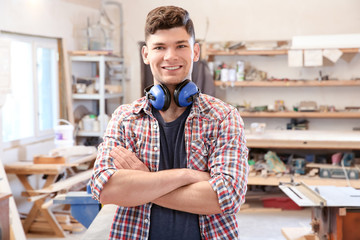 Handsome young carpenter in workshop