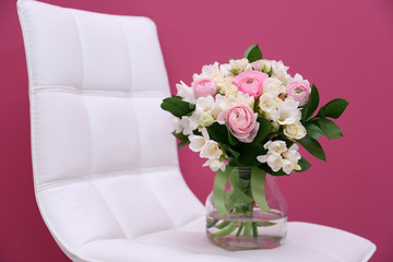 Beautiful bouquet with freesia flowers on white chair