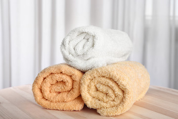 Fototapeta na wymiar Clean rolled towels on wooden table