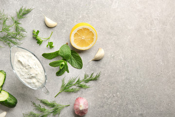 Delicious yogurt sauce in gravy boat with ingredients on table