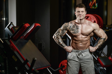 Naklejka premium Strong and handsome athletic young tattoo man with muscles