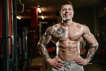 Strong and handsome athletic young tattoo man with muscles