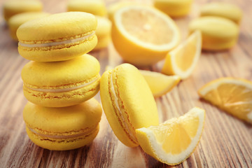 Tasty lemon macarons on wooden table, closeup