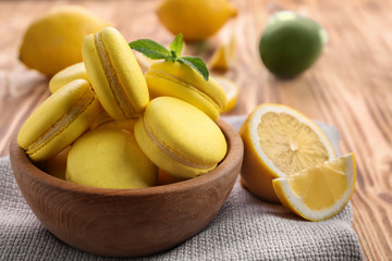 Composition with tasty lemon macarons on wooden table, closeup