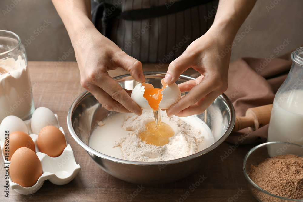 Poster woman making dough for cinnamon rolls in kitchen