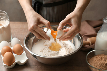 Woman making dough for cinnamon rolls in kitchen