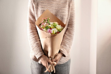 Fototapeta premium Kobieta trzyma pięknego bukiet z frezją na lekkim tle