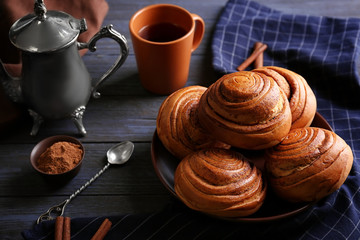Round plate with yummy cinnamon rolls on kitchen table