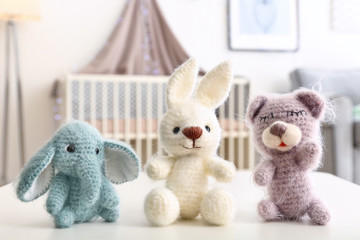 Adorable crochet baby toys on table in bedroom