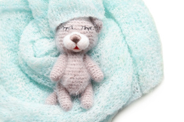 Woolen toy made in crochet with baby clothes isolated on white