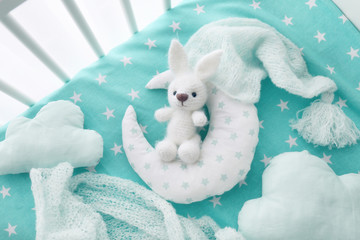 Adorable handmade crochet toy with baby clothes and pillows in crib - Powered by Adobe