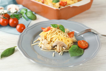 Plate with delicious roasted turkey tetrazzini on wooden table