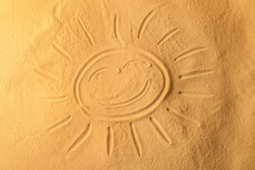 Fototapeta na wymiar Sun drawn on sea sand, closeup view