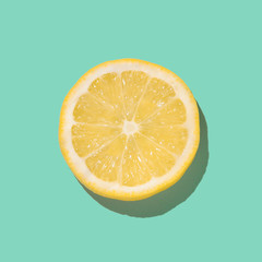 Fresh lemon slice close up on bright blue background. Flat lay. Summer concept.
