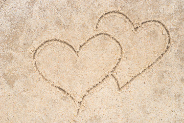 two hearts drawing in sand