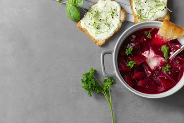 Delicious beet soup with sour cream and parsley on kitchen table