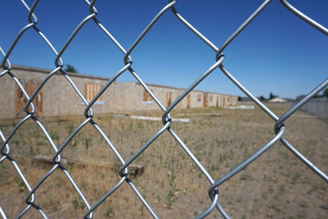 Fototapeta premium abandoned homes behind chain link fence