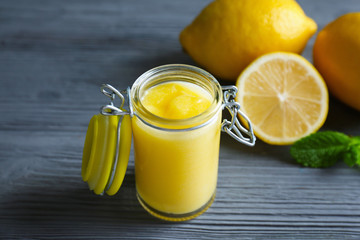 Beautiful composition with delicious lemon curd on wooden table