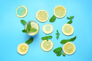 Glass of delicious lemonade on color background