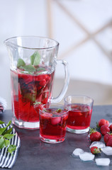 Delicious strawberry lemonade in glassware on kitchen table