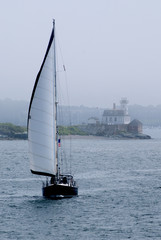 Sailboat Passes By Rose Island Lighthouse in the Fog in Newport, Rhode island