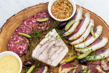 Cold smoked meat plate with, proscius on white wooden desk.