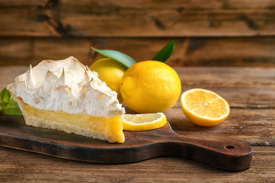 Piece of yummy lemon meringue pie on wooden table