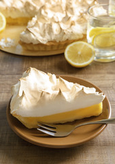 Piece of delicious lemon meringue pie on plate