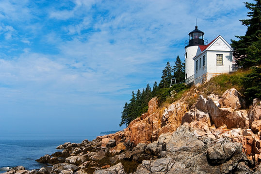 Maine lighthouse over rocky cliffs in Acadia National Park.