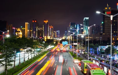 Foto op Plexiglas NANNING, CHINA - Qingxiu District busy traffic with light trails and high illuminated  buildings © creativefamily
