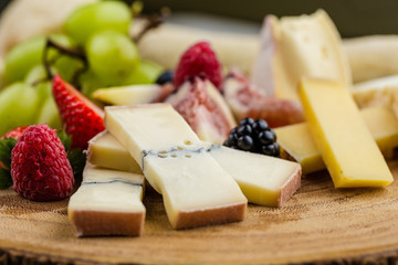 Cheese plate with bread grapes and strawberries