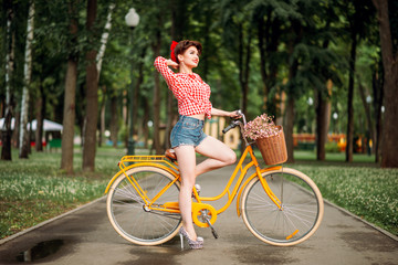 Pin-up girl on bicycle, vintage american fashion