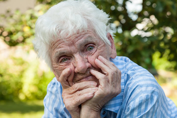 Portrait einer alten lebenserfahrenen Frau, Hände stützen das Gesicht