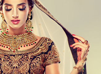 Portrait of beautiful indian girl. Young hindu woman model with golden kundan jewelry set ....