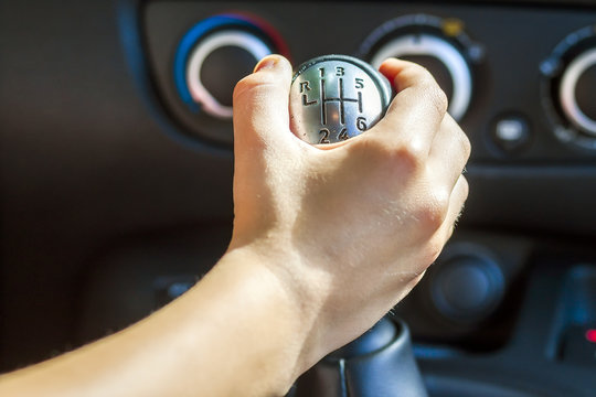 Driver hand shifting gear shift knob manually, selective focus