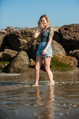 Young woman can't help but smile when feeling ocean water.