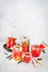 Set of watermelon summer drinks and cocktails: sangria, juice cooler cocktail, infused detox water, watermelon vodka shot. On a white marble table. Copy space