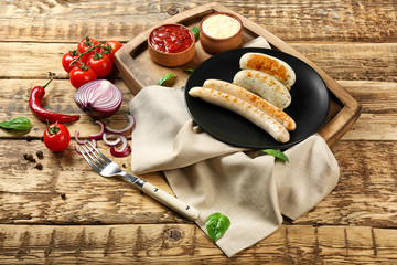 Composition with yummy grilled sausages on wooden table