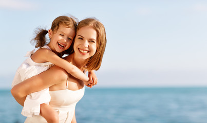 happy family at beach. mother hugging child daughter
