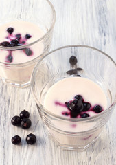 Dairy product made with the berries of black currant in a glass on wooden table,top view.