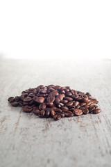 roasted coffee beans on wood textured table with white background
