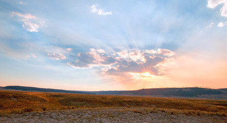 Sunbeams and sunrays through sunset clouds in the Hayden Valley in Yellowstone National Park in Wyoming USA