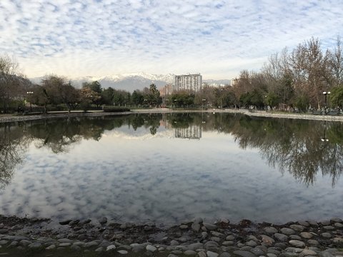 Clouds reflex on a pond water at a park in Chile