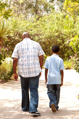 Rear view of an African American father and son taking a walk.